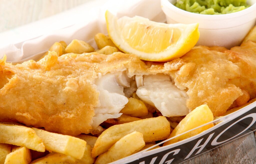 Fish, chips, and mushy peas served with a lemon slice from the Best fish and chips restaurant in Brixham, Devon, UK